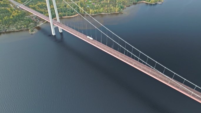 上图是一辆白色拖车穿过瑞典Hogakustenbron大桥。无人机航拍