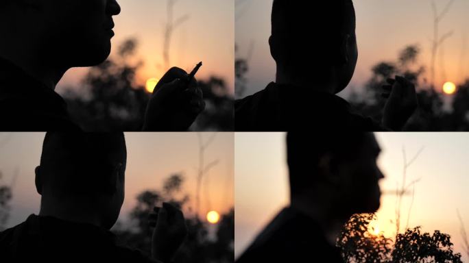 夕阳下男人抽烟剪影