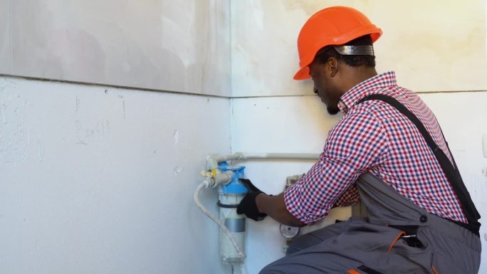 黑色水管工在新公寓安装或更换滤水器