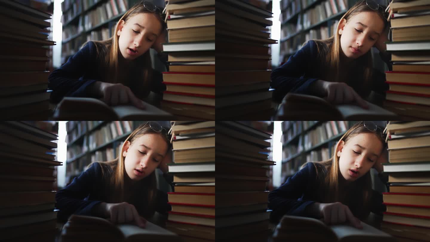 女孩坐在图书馆的书架之间，大声朗读书籍以寻找信息。花时间在文献库中获取新知识。学校文学的有趣作品。