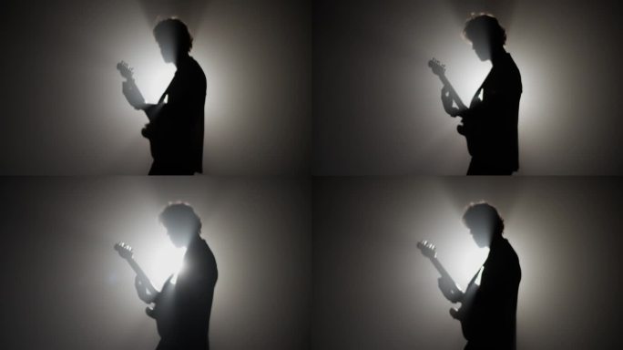 摇滚音乐家在聚光灯下弹吉他的剪影