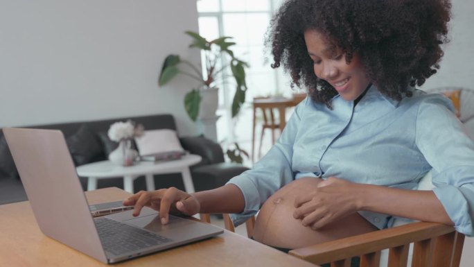 怀孕的非洲妇女亲切地问候在子宫里挣扎的婴儿