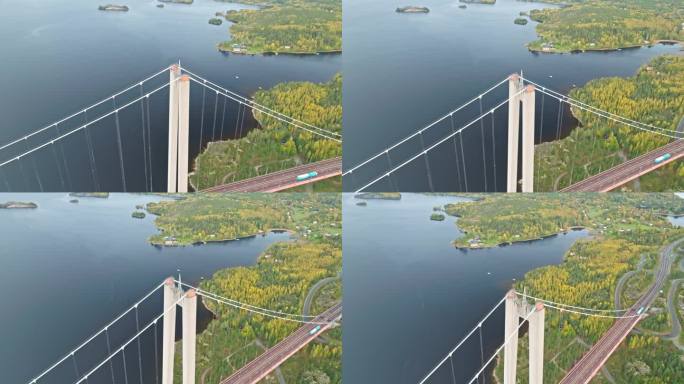 鸟瞰图:瑞典Hogakustenbron悬索桥的混凝土塔在五颜六色的树木上。