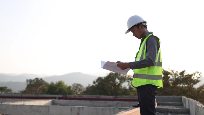 工程师在施工现场，检查建筑结构图纸的正确性。