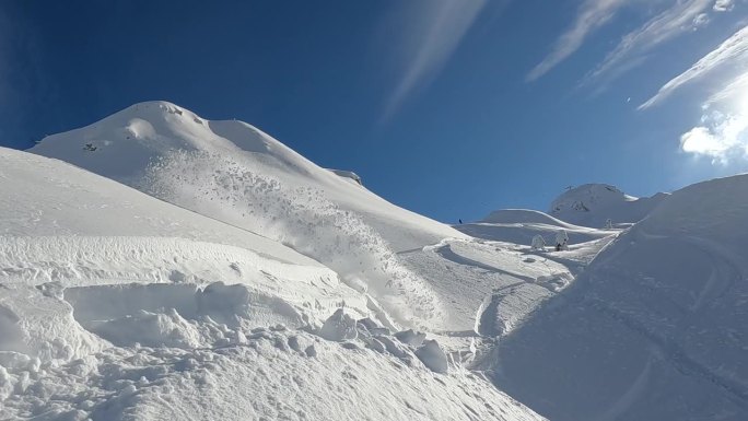 慢镜头:活跃的女士在单板滑雪时喷出大团雪粉