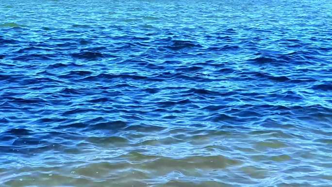 风吹蓝色水面起伏的波浪