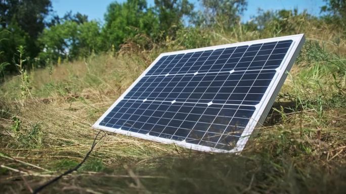 躺在地上的便携式太阳能电池板在大自然户外特写