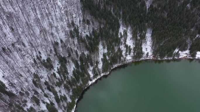 冬季火山口湖的空中无人机视图。在罗马尼亚特兰西瓦尼亚塞克勒兰的斯芬达安娜湖上空飞行