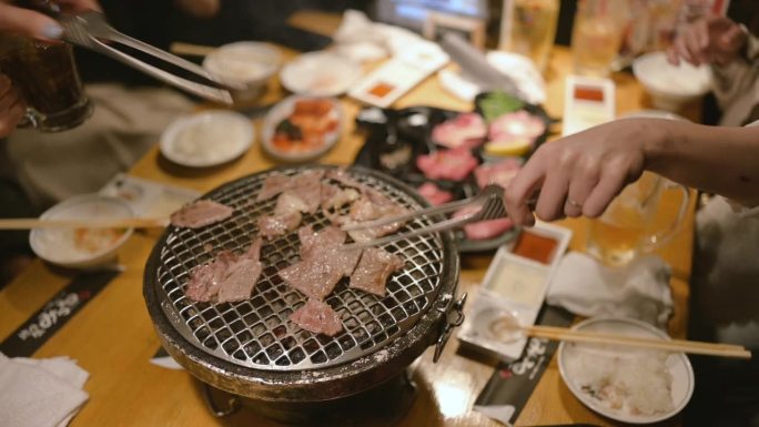 在日本的一家餐馆里，一群妇女正在吃传统的日式牛肉烤肉烧肉和牛肉