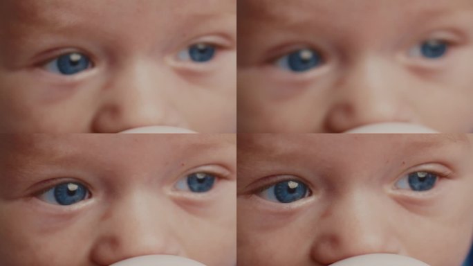 可爱的蓝眼睛小男孩在喝牛奶时看向别处的特写