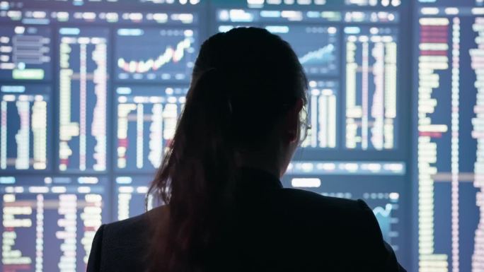 女商人分析师看着电脑屏幕上的投资图表并思考