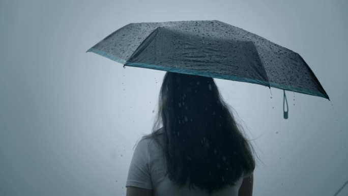 一个女人在雨中打着伞