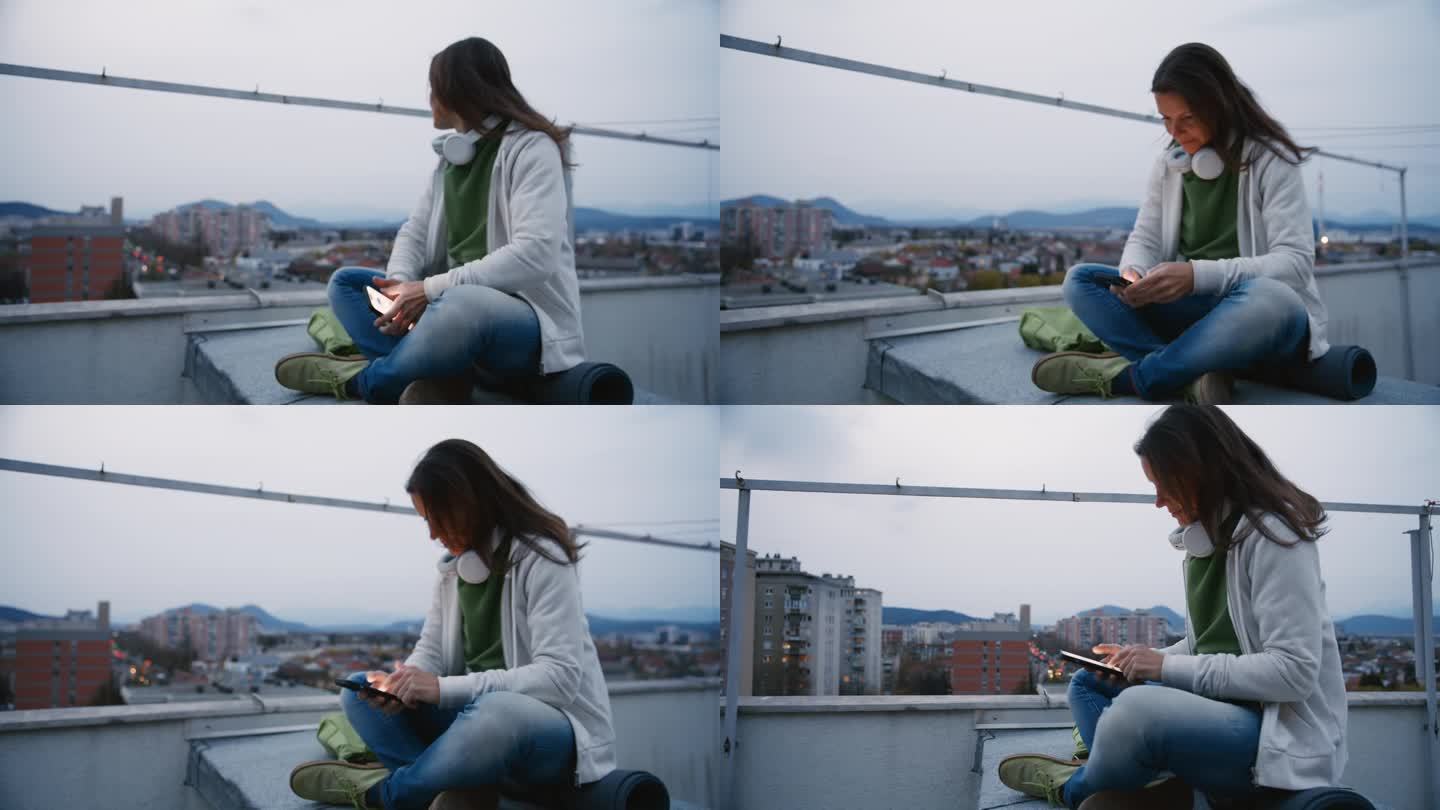 女人坐在城市屋顶上使用智能手机
