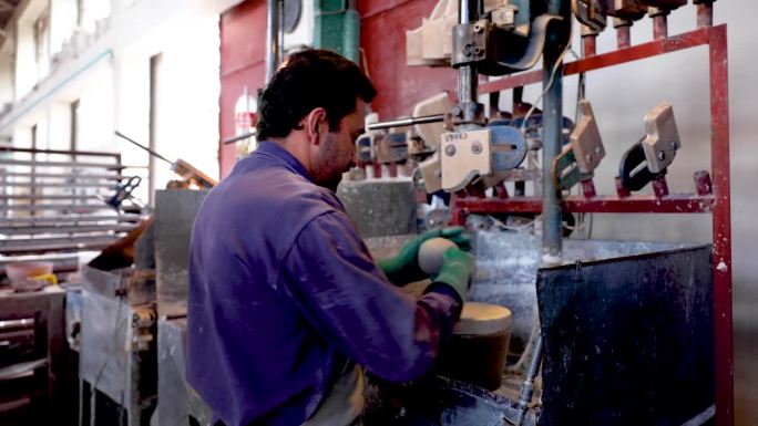 在陶瓷厂，成熟的工匠将一块粘土切成薄片，放在机器上制作碗