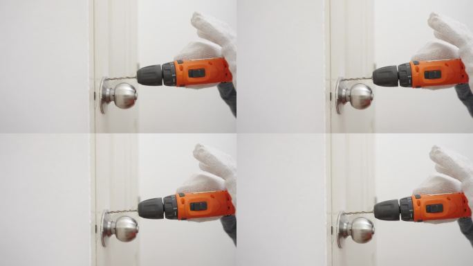 近距离使用无绳电钻的人的手
修理门把手。