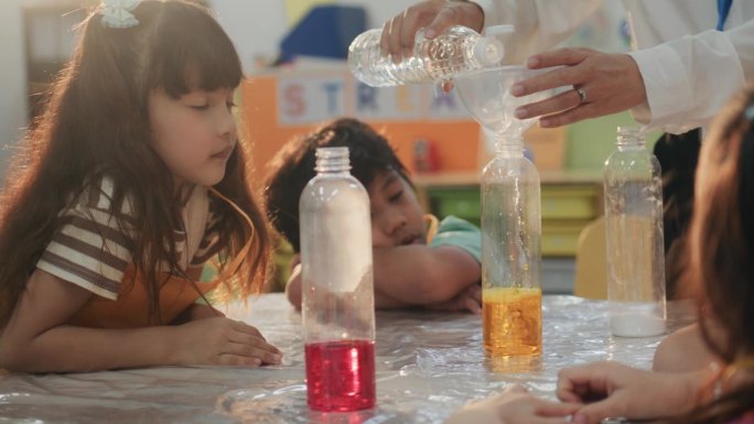 不同的孩子们在充满好奇的学生的课堂上学习科学实验。
