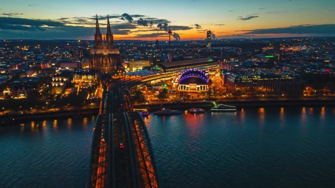 鸟瞰图:日落时分，德国科隆市中心的霍亨索伦桥上的科隆大教堂，穿过科隆中央车站和音乐圆顶