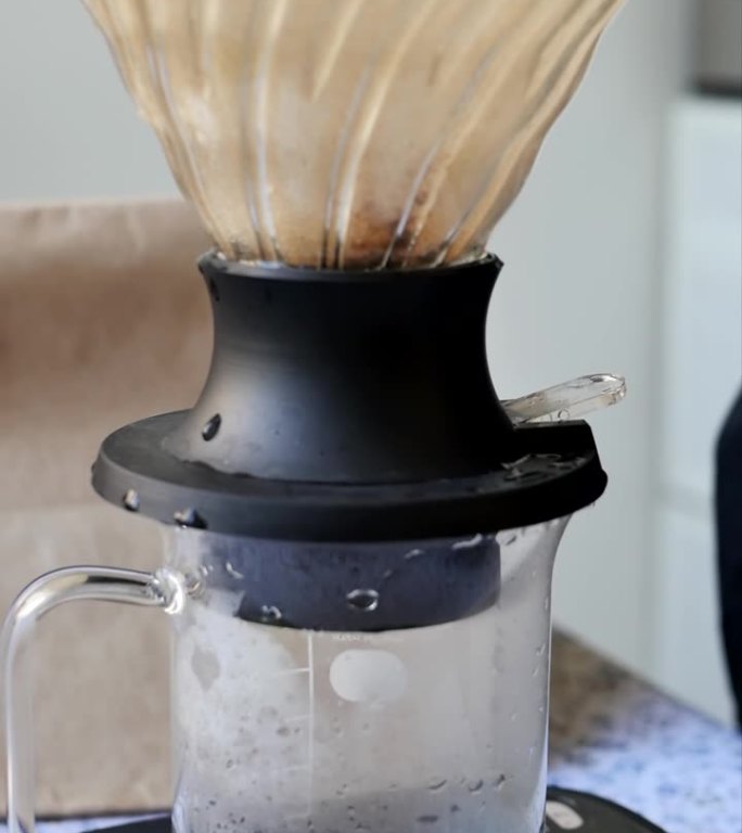 将磨碎的芳香咖啡倒入带有过滤器的杯子中，使用滴灌方法制备咖啡饮料。