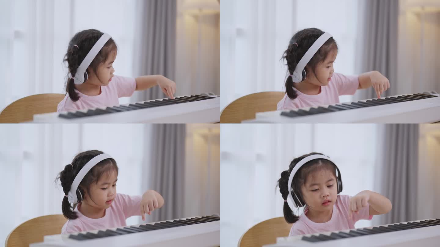 亚洲可爱的女孩微笑着，戴着白色耳机在家里的客厅里学习在线钢琴音乐。隔离期间孩子在家活动的想法。音乐学