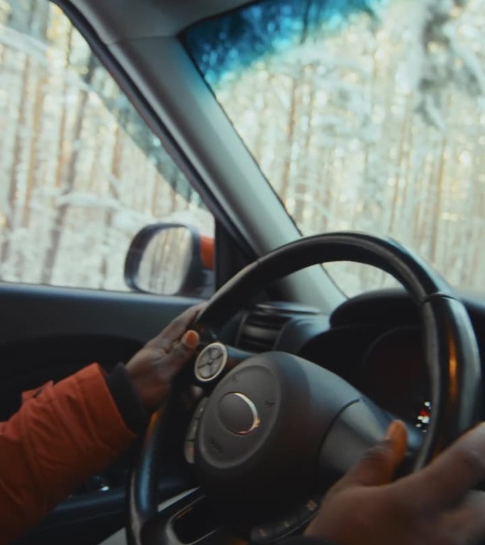 在树林中的雪地里，男性双手驾车