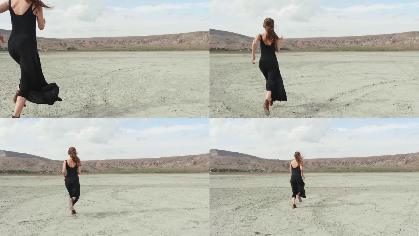 在沙漠地区的背景下，一个穿着黑色连衣裙的女人沿着一条土路逃避问题。一个在大城市逃避孤独的心理状态的象