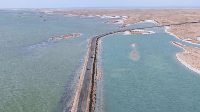 航拍汽车行驶在青海西台吉乃尔湖中的公路上