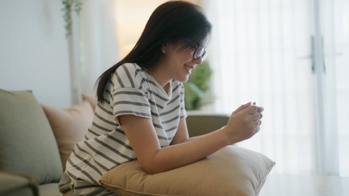 快乐的亚洲妇女看着阳性妊娠测试，欣喜的阳性结果