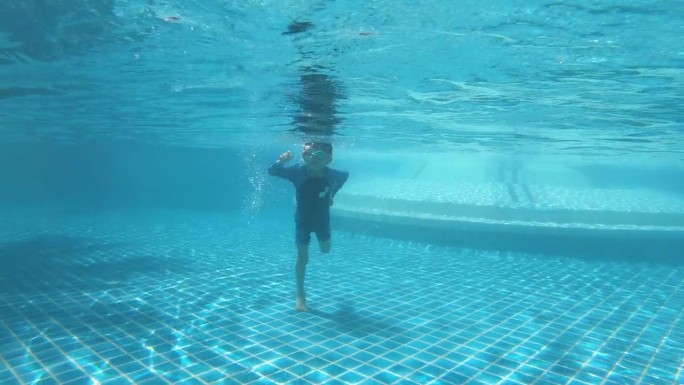 孩子享受暑假，快乐的男孩在阳光明媚的日子跳进游泳池，4K动态场景