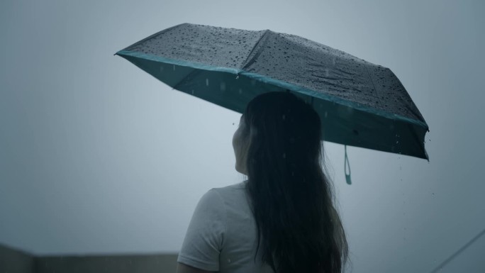 一个女人在雨中打着伞