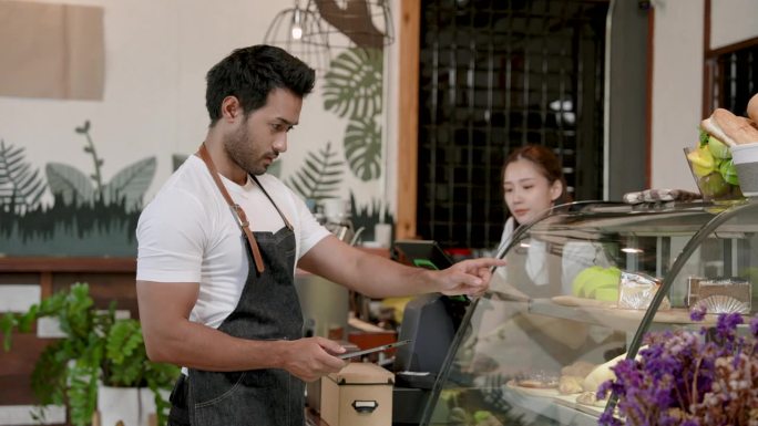 印度男子帮妻子数橱柜里的糖果。他是一家小型家庭咖啡店的老板。为配合电脑屏幕，准备开一家咖啡厅，随时接