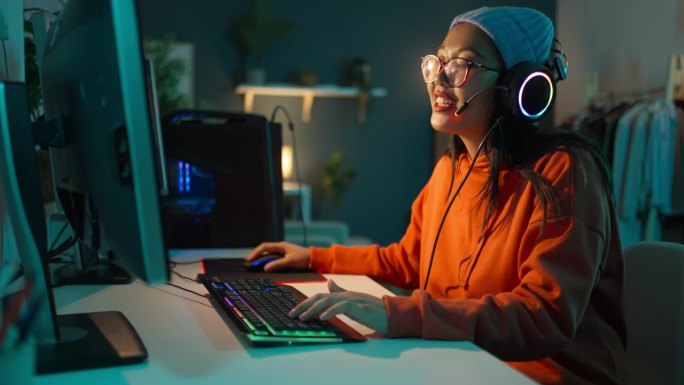 女玩家亚洲种族，在PC上玩视频游戏，在流