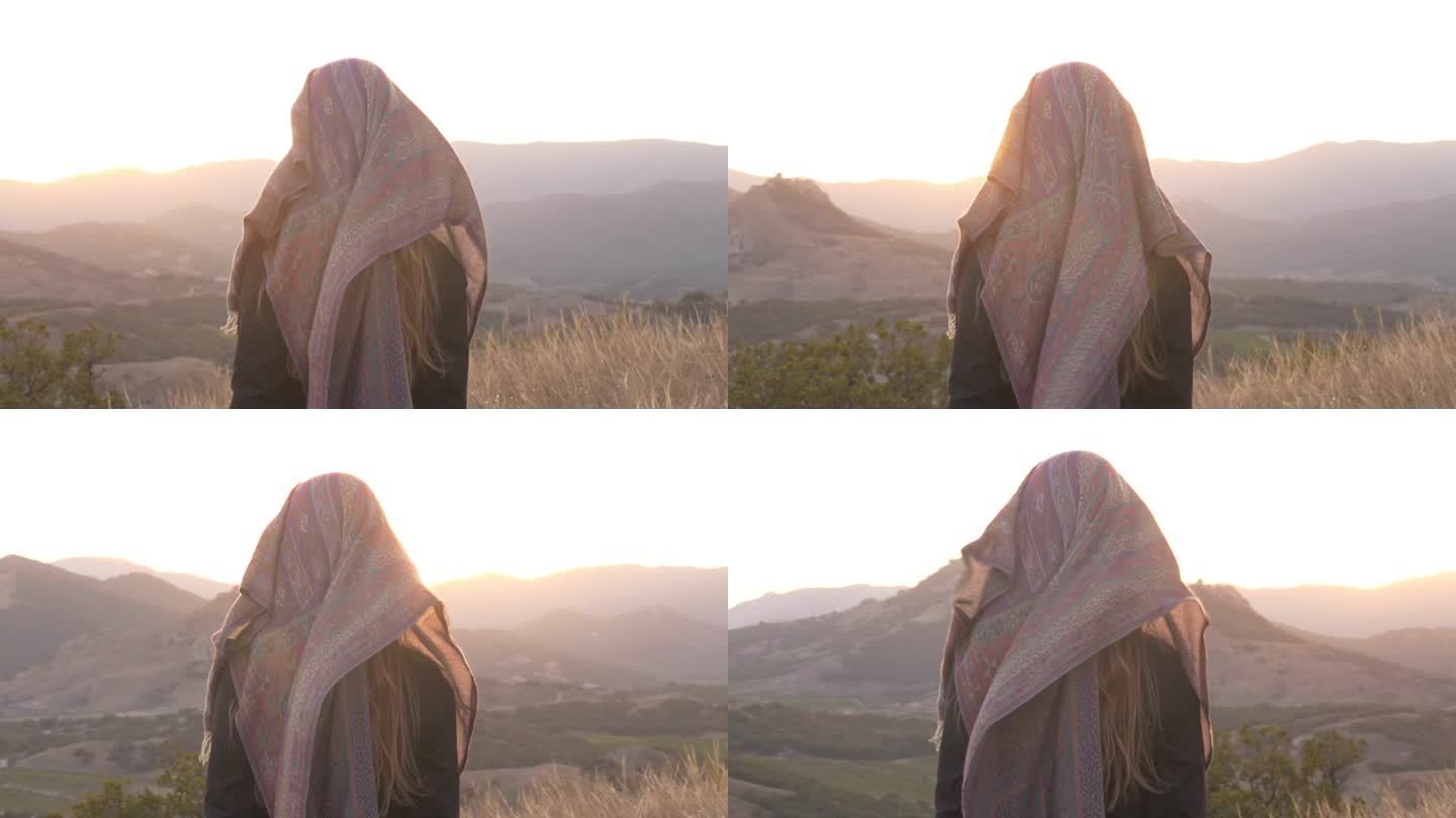 孤独的女人戴着面纱看世界。在脸上戴围巾代表一种心理状态。心理与健康