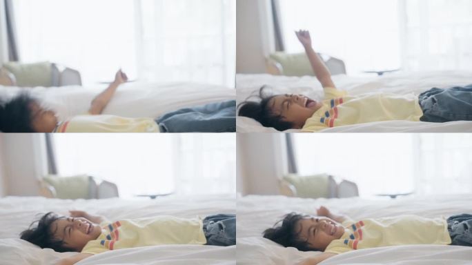 侧视图可爱的小男孩休息，躺在床上，双臂举起，享受休息，躺在清新的白色床单上，独自在家放松微笑。