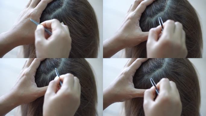 一个女人用梳子拔白头发。