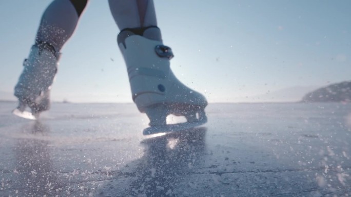 DOF，超慢动作，特写:女士踩着冰鞋刹车，冰四处飞舞