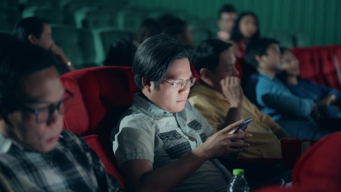 亚洲男人对在电影院看电影的时候用手机的人很恼火。
