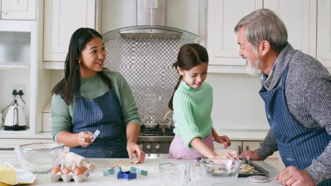家庭，烘焙和厨房的快乐，学习的乐趣，孩子的发展和联系在家里玩。爷爷，女人和孩子用围裙做饭，支持和甜点