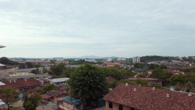 从右到左的慢拍拍摄了马来西亚马六甲的高角度城市全景，这是一个傍晚，天空布满了云。