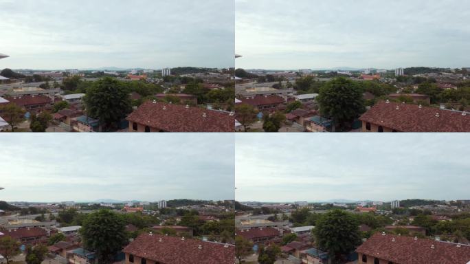 从右到左的慢拍拍摄了马来西亚马六甲的高角度城市全景，这是一个傍晚，天空布满了云。