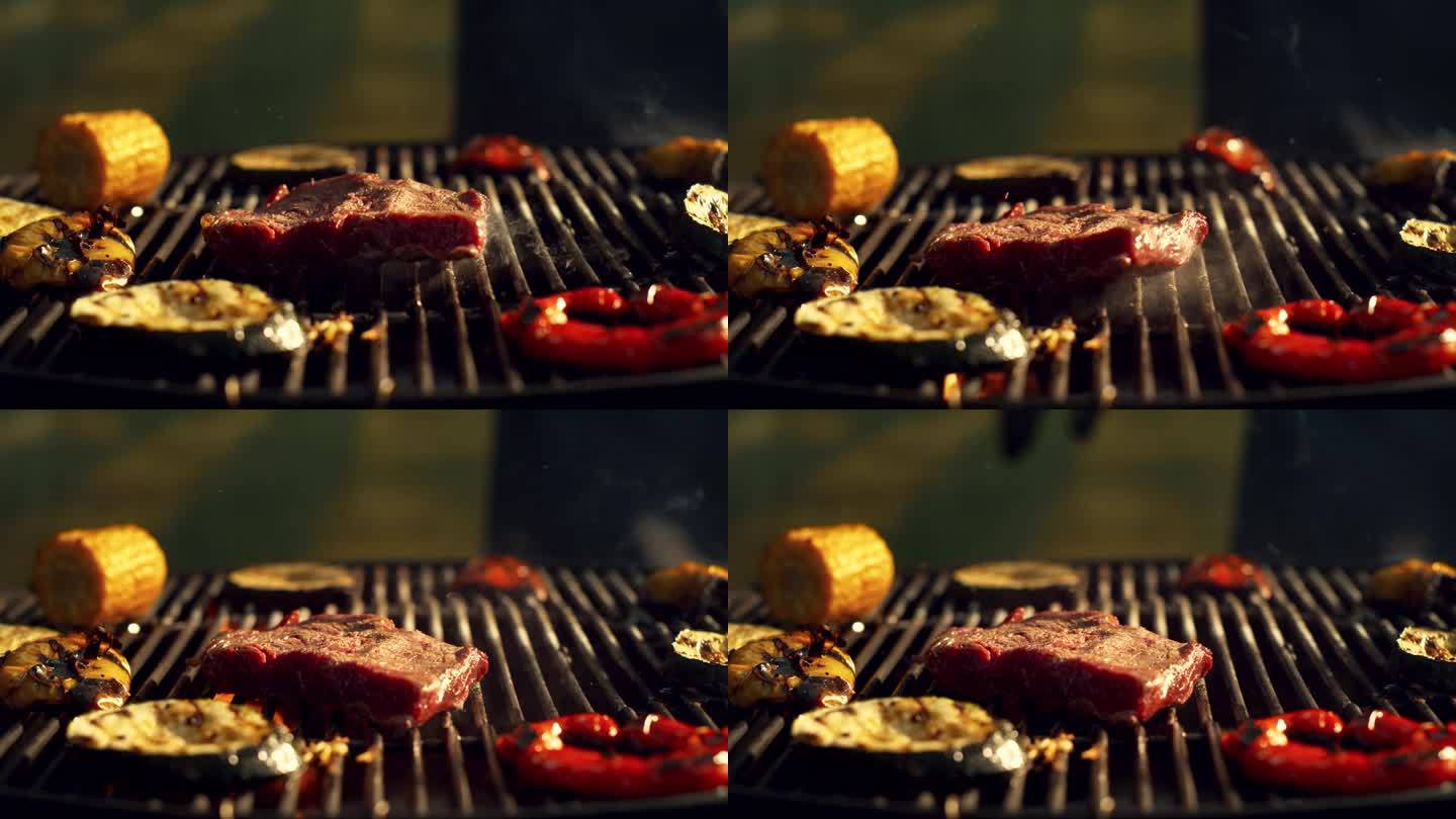 肉排、甜椒、洋葱、小胡瓜和玉米在炭火烤架上烤熟。用于商业或广告的电影慢动作镜头。喷出的火焰触摸美味的