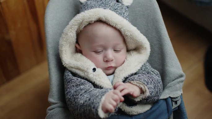 可爱的小男孩在家里玩毛皮大衣放松