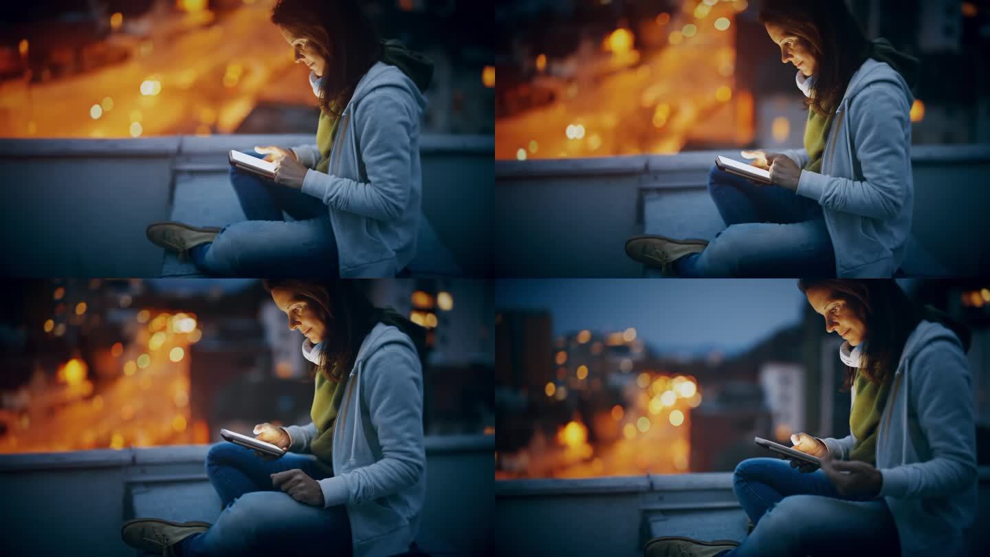 女人晚上坐在城市屋顶上用智能手机发短信