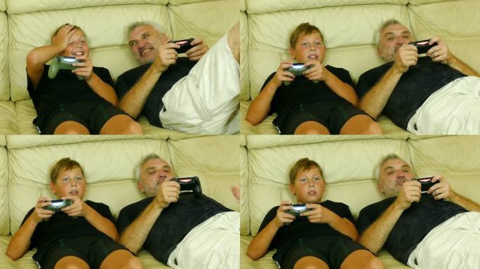 父亲和儿子一起在家里的沙发上玩电子游戏