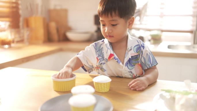 家庭自制的幸福:亚洲孩子在他们的厨房里烹饪甜蜜的回忆。