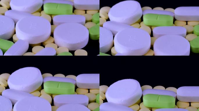 药品和药片相机运动。堆不同的新潮色彩药丸躺在黑色的桌子上跟踪拍摄