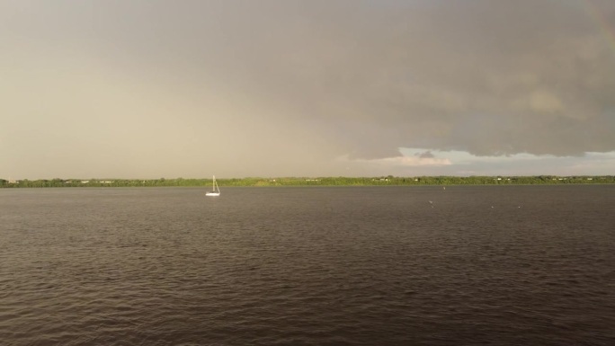 风暴过后，一艘帆船在水面上的视频，天空乌云密布，海鸥四处飞翔