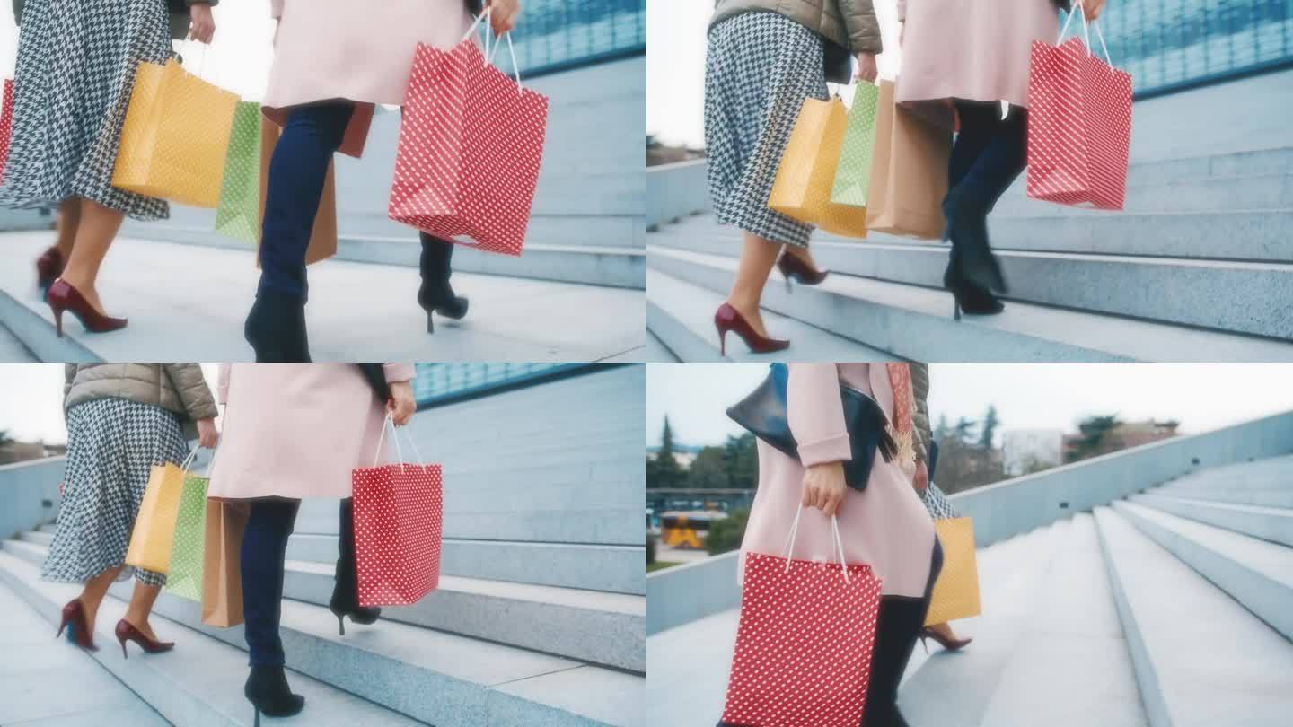 两个难以辨认的穿着细高跟鞋的女人拎着购物袋走上城市的楼梯