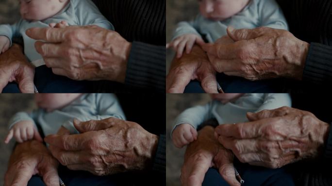 在家，小男孩的小手握着爷爷的手指的特写