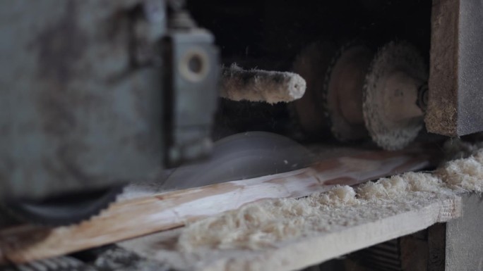 现代锯木厂自动圆锯切割木板的近景。采用现代工艺对板材进行磨削加工。工业用天然材料的木工工作。