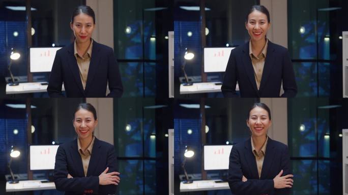 肖像的行政女商人聪明的休闲装看着相机和微笑，快乐在现代夜间办公室工作场所。年轻的亚洲女士站在现代会议